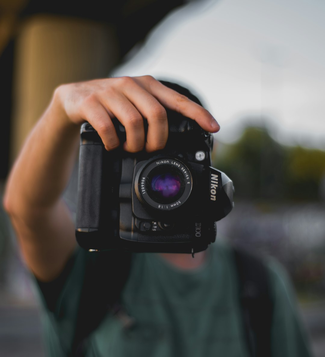 person holding Nikon DSLR camera