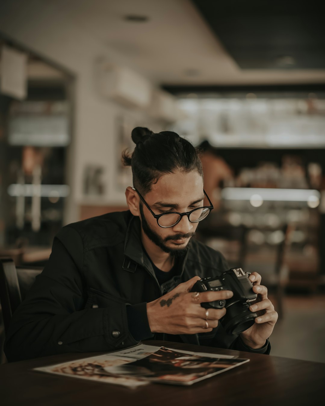 man in black jacket holding black dslr camera