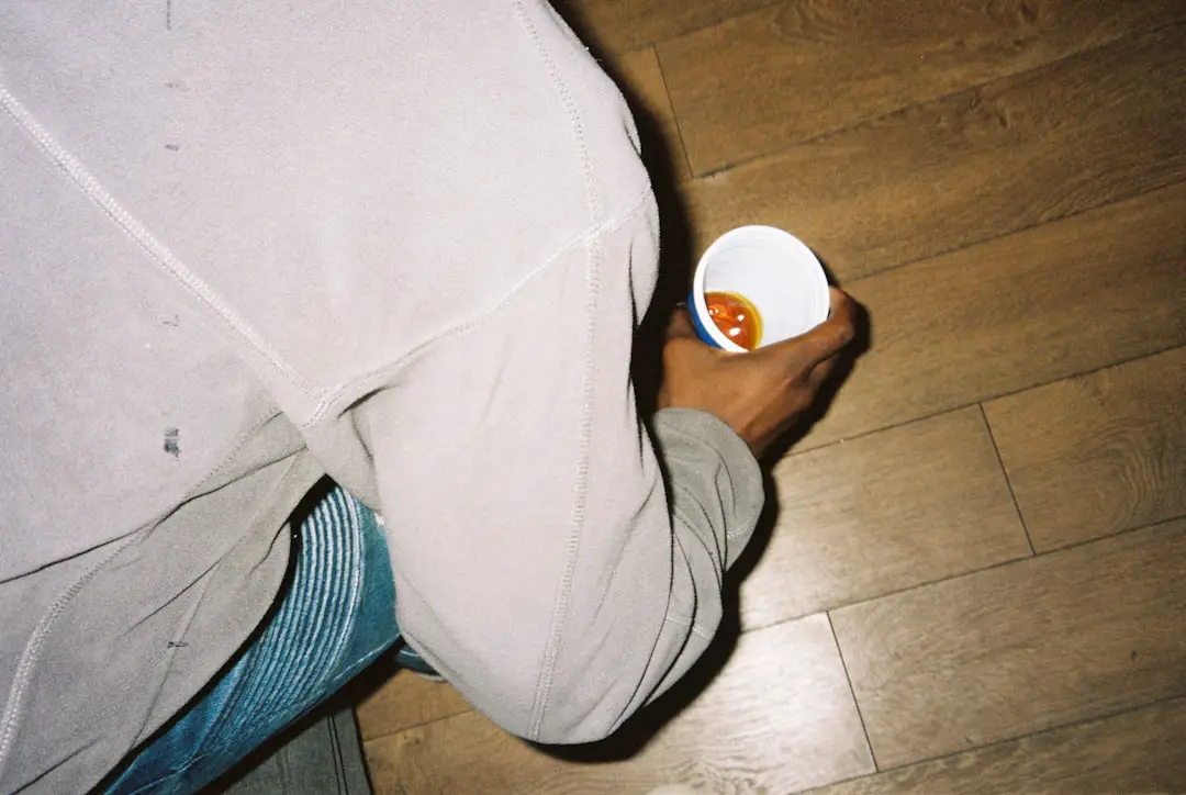 person in gray pants holding white plastic cup