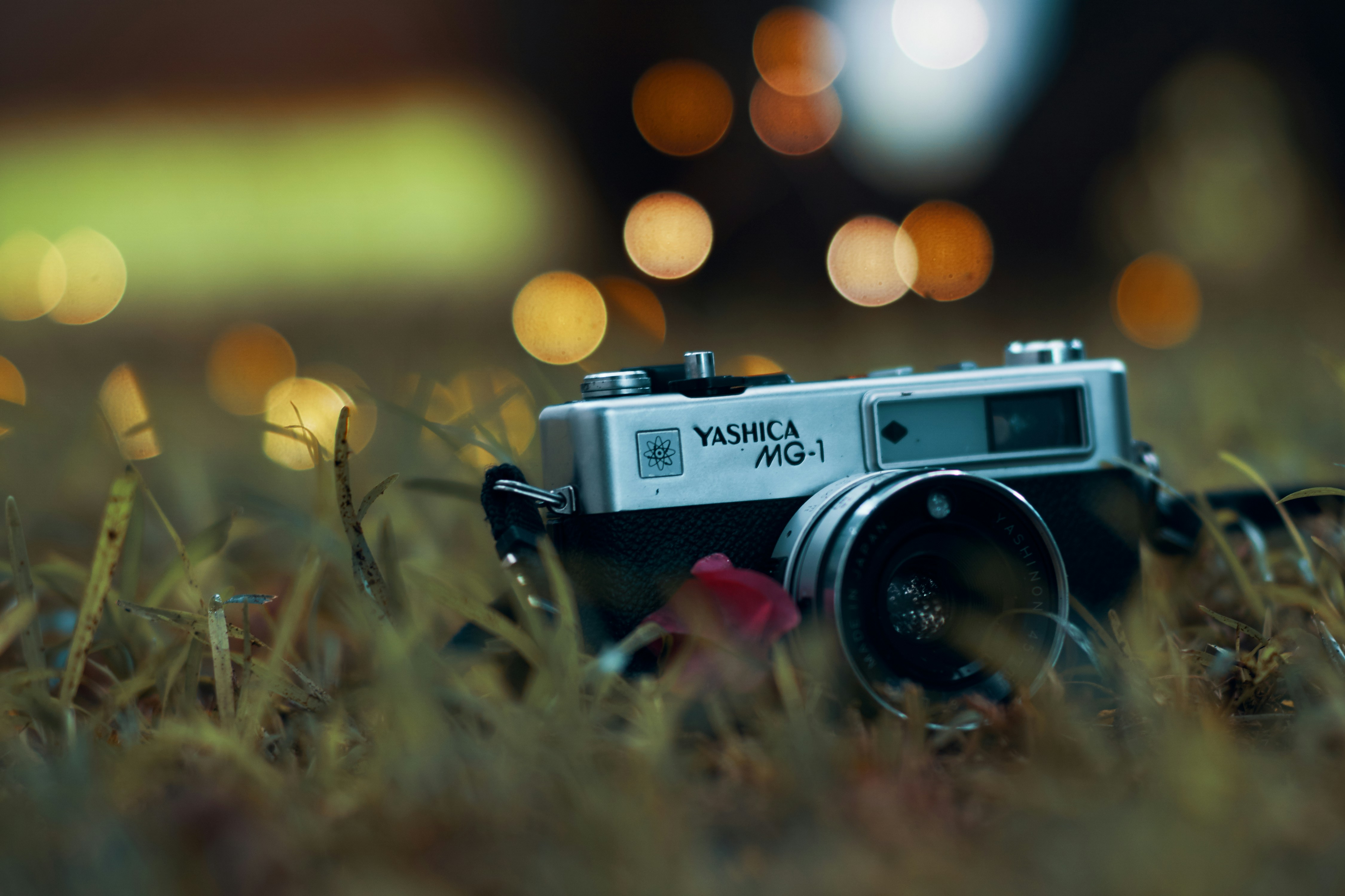 close-up photography of gray Yashica MG-1 camera on green grass
