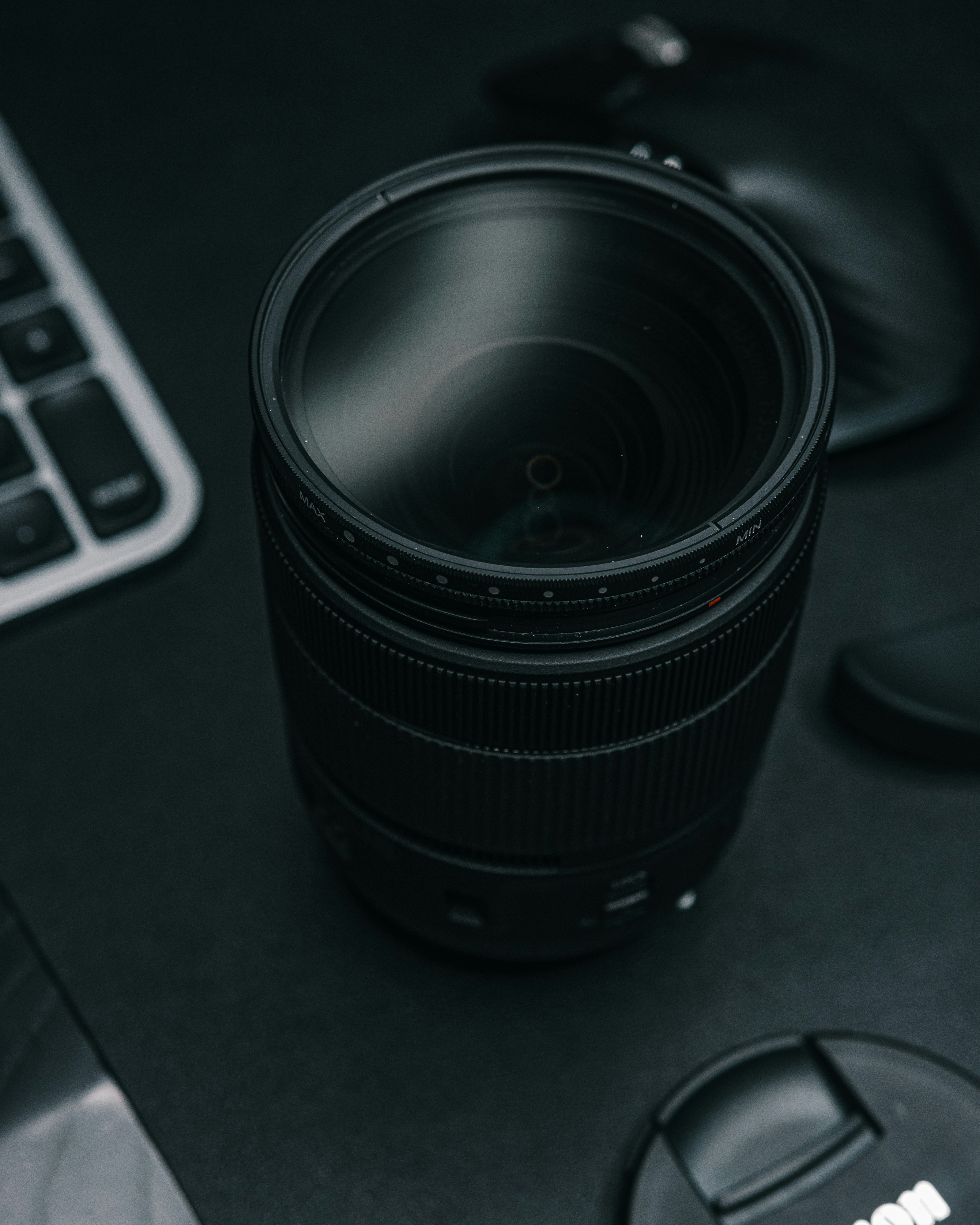 a camera lens sitting on top of a desk next to a keyboard